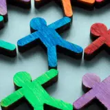 Colorful wooden figures represent a diverse community, highlighting the importance of EDI (Equity, Diversity, Inclusion) over DEI (Diversity, Equity, Inclusion).