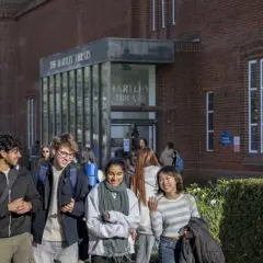 Students walk past Hartley Library, perhaps discussing their graduate certificate programs.
