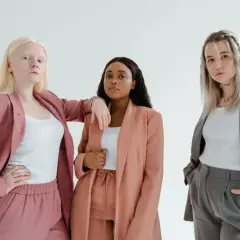 Three diverse women in stylish suits, embodying the spirit of a female leadership program.