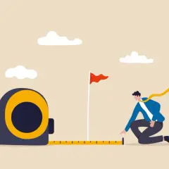 A man measures the distance to a goal flag, symbolizing progress and planning at an internal communications conference.