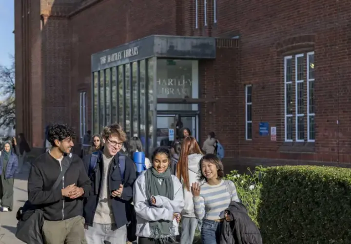 Students walk past Hartley Library, perhaps discussing their graduate certificate programs.