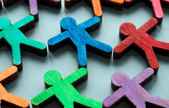 Colorful wooden figures represent a diverse community, highlighting the importance of EDI (Equity, Diversity, Inclusion) over DEI (Diversity, Equity, Inclusion).
