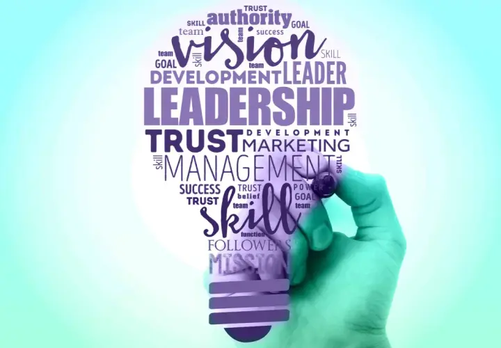 A hand draws a lightbulb filled with words like "Leadership," "Vision," and "Skill," symbolizing effective leadership branding.