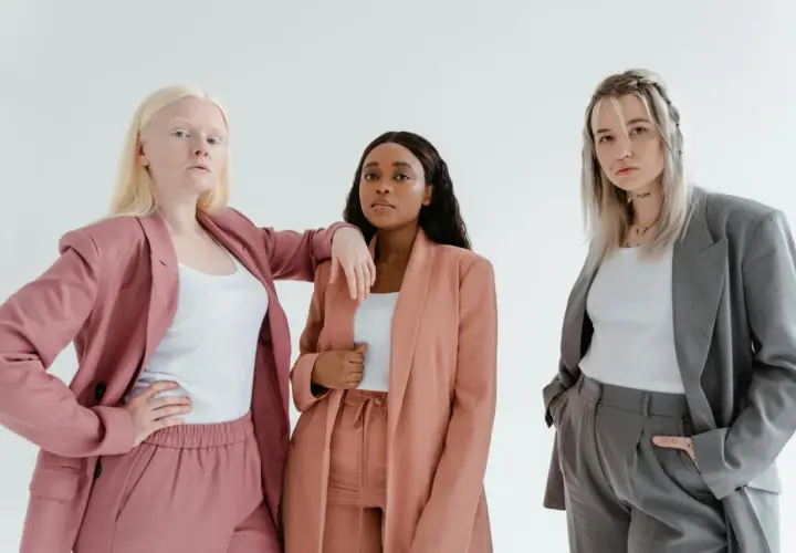 Three diverse women in stylish suits, embodying the spirit of a female leadership program.