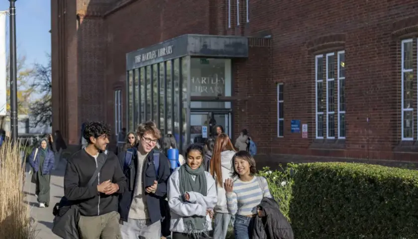 Students walk past Hartley Library, perhaps discussing their graduate certificate programs.