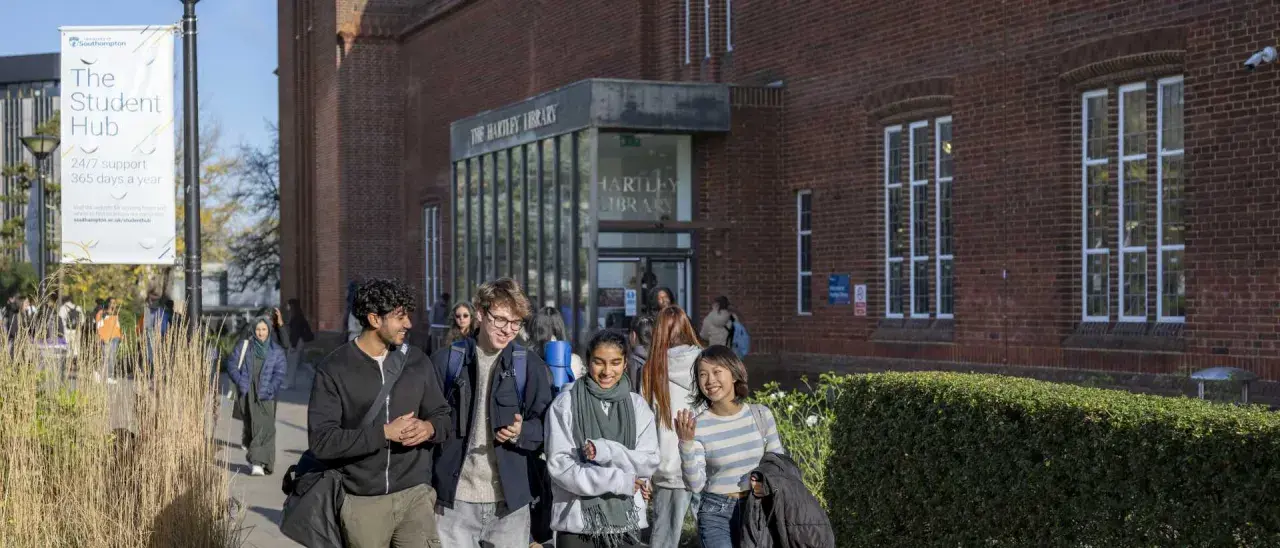 Students walk past Hartley Library, perhaps discussing their graduate certificate programs.
