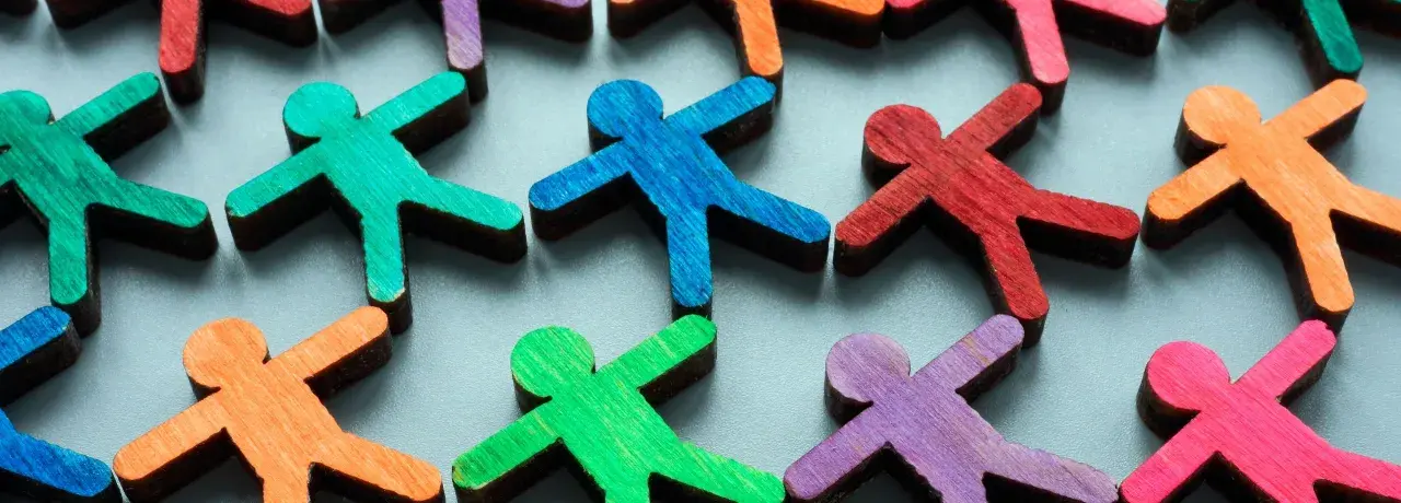 Colorful wooden figures represent a diverse community, highlighting the importance of EDI (Equity, Diversity, Inclusion) over DEI (Diversity, Equity, Inclusion).