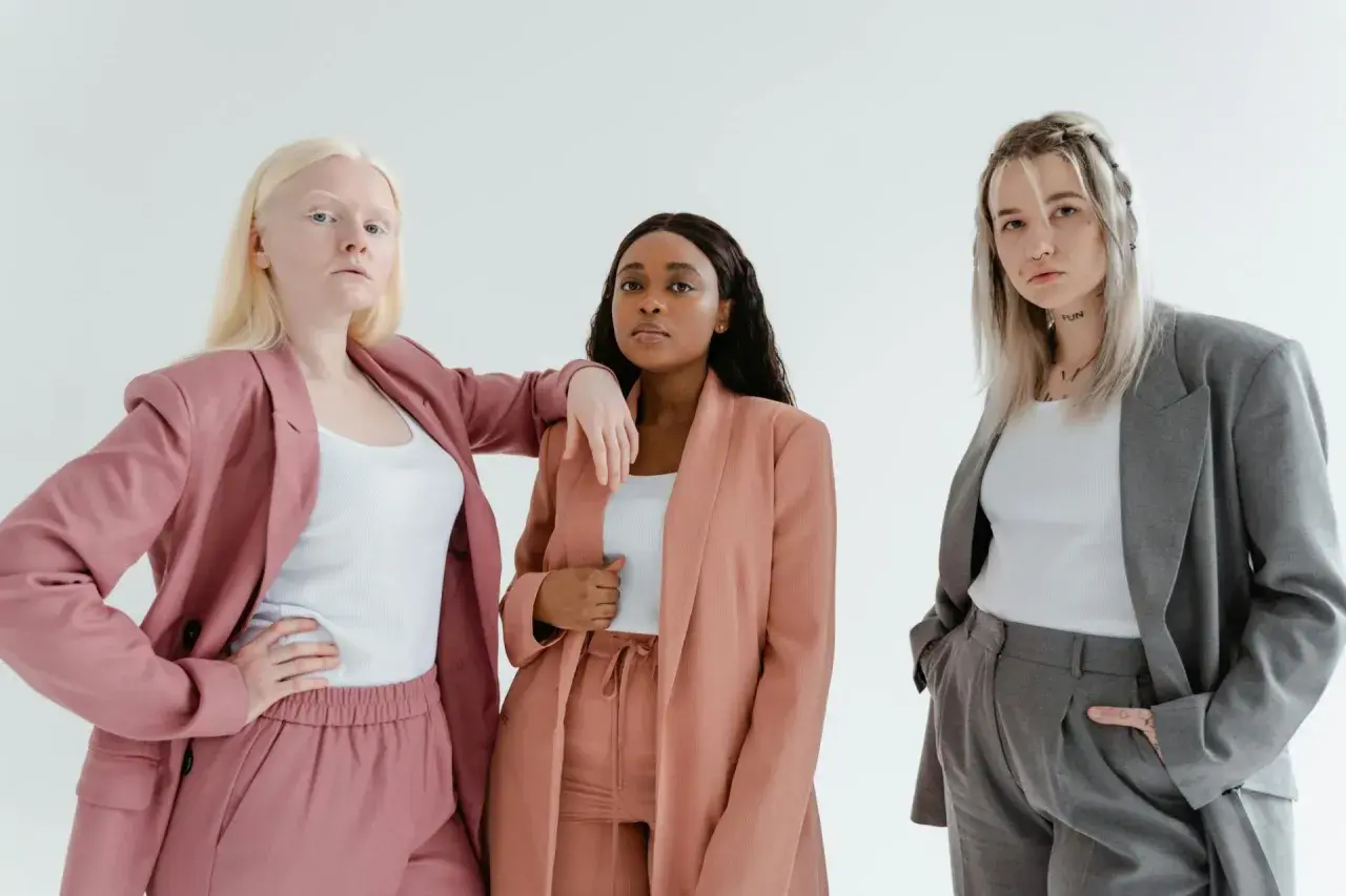 Three diverse women in stylish suits, embodying the spirit of a female leadership program.