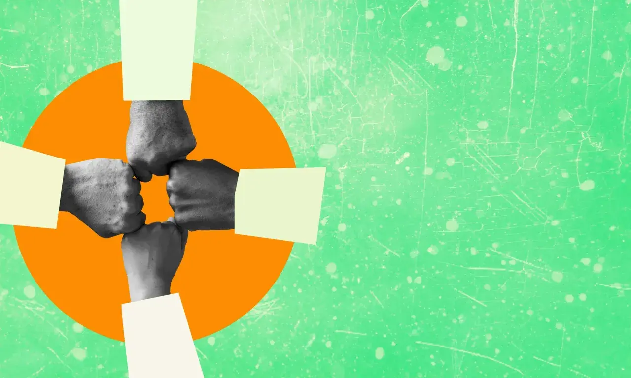 Four fists bump in a circle, symbolizing authentic leadership and teamwork.