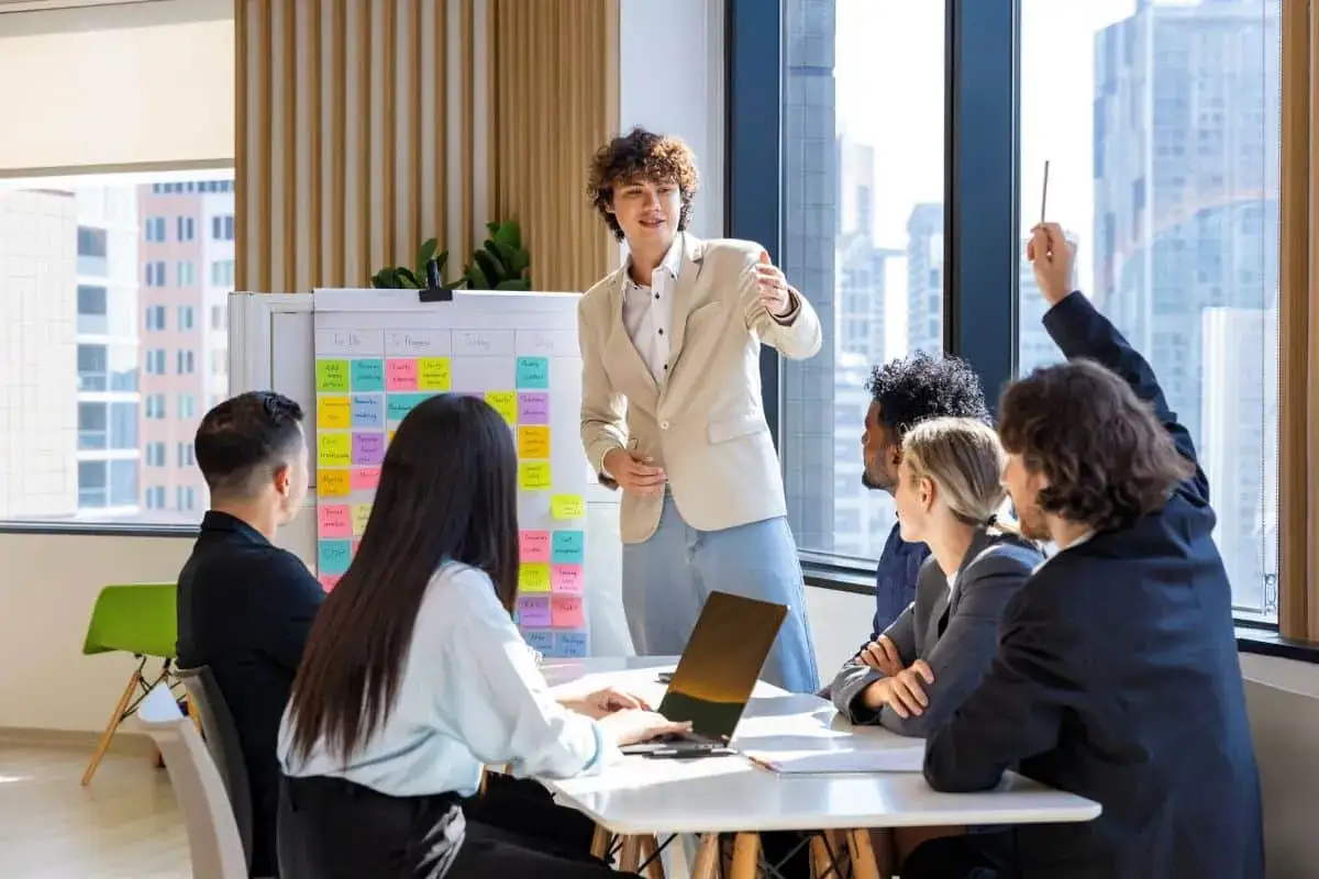 A team brainstorms ideas on a whiteboard covered in sticky notes, fostering a dynamic environment to increase employee engagement and motivation.