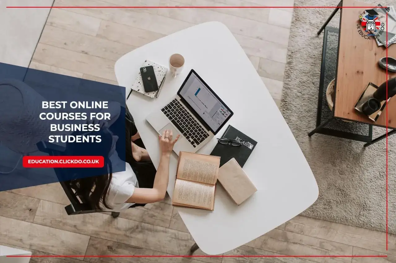 A student studies for an online associates degree in business, with a laptop, books, and phone on a desk.