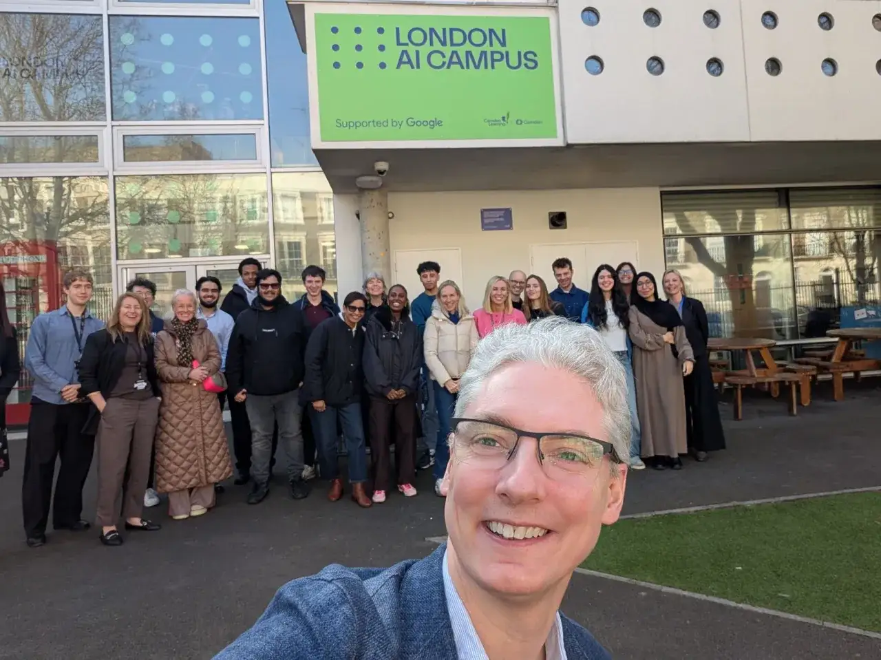 A group poses outside the London AI Campus, supported by Google, likely after completing a Google AI Essentials course.