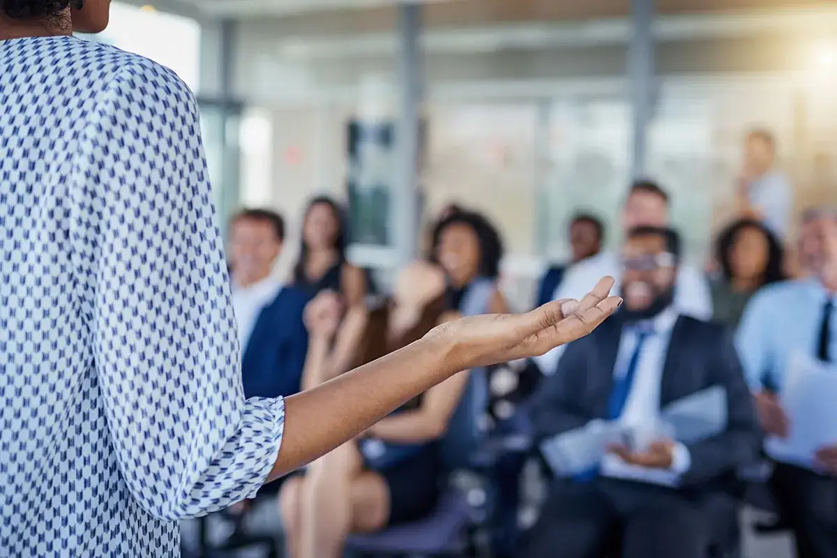 A speaker addresses an audience, demonstrating effective leadership branding through engaging presentation.