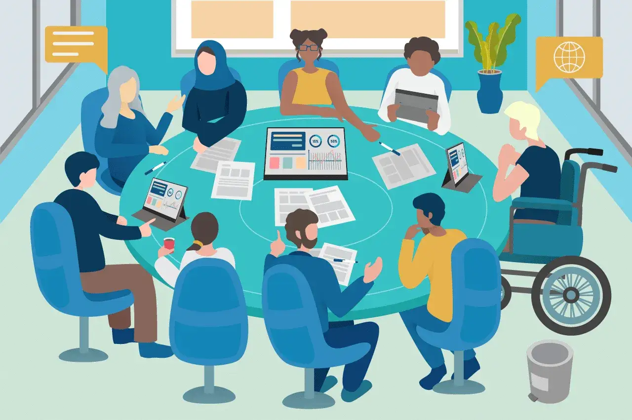 A diverse group discusses workplace dei issues around a table, including a person in a wheelchair.