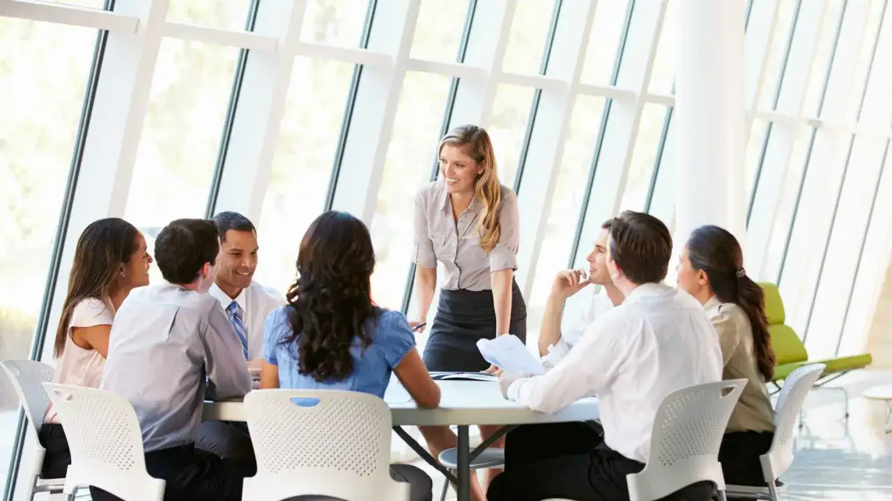 A diverse team collaborates in a bright meeting room, fostering trust and psychological safety as they discuss ideas.